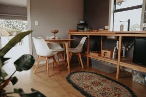 a living room with a table and two white chairs at Kay Bell in Masterton