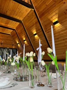 a table with white flowers in glass vases at Darchi • დარჩი in Batumi