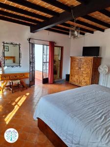 a bedroom with a bed and a desk and a mirror at Hotel Cielito Lindo, Taxco in Taxco de Alarcón