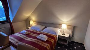 a hotel room with a bed with towels on it at Hotel Hradna brana in Bratislava