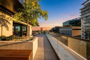 a balcony with a view of a city at sunset at Domain House Executive in Melbourne