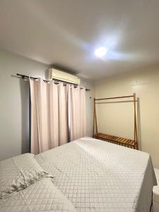 a bedroom with a bed and curtains in it at Apartamento CONFORT 2Q in Rio Branco