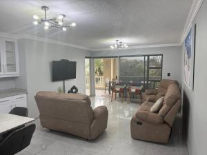 a living room with two couches and a dining room at 64 Laguna La Crete in Uvongo Beach