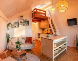 ein Wohnzimmer mit Treppe und Küche in der Unterkunft Sunsethüsli in Därligen