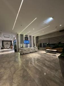 a lobby with a couch and a flat screen tv at AuraStays in Dargai