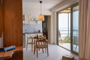 a kitchen with a table and chairs and a balcony at Lorraine's Boutique Suites in Lourdata