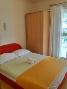a bedroom with a bed with a towel on it at Apartments Biser in Podgora