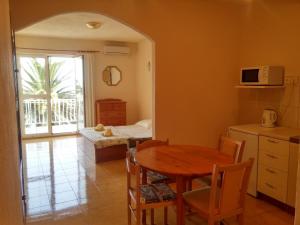 a kitchen and dining room with a table and a dining room tablektop at Apartments Biser in Podgora +24 photos