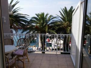 a balcony with palm trees and a view of the water at Apartments Biser in Podgora