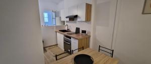a small kitchen with a small table and a counter at Blue T in Saint-Claude