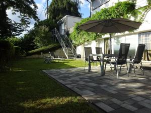 a table and chairs with an umbrella in a yard at Apartment Rheintalblick 2 by Interhome in Linz am Rhein