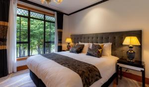 a bedroom with a large bed with a large window at Hana Lodge in Rotorua +79 photos