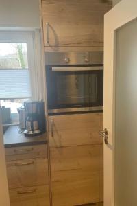 a kitchen with a wooden cabinet with a microwave at Apartment Becker by Interhome in Bad Neuenahr-Ahrweiler