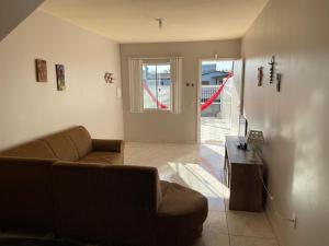 a living room with a couch and a table at Ares de Salinas - 100 metros da praia in Cidreira