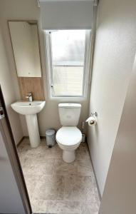 a small bathroom with a toilet and a sink at Parkside Retreats in Kirby Misperton +9 photos