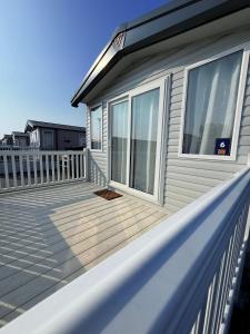 a house with a large wooden deck on a balcony at Parkside Retreats in Kirby Misperton