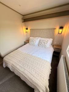 a bedroom with a large white bed with two lamps at Parkside Retreats in Kirby Misperton