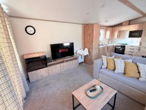 a living room with a couch and a tv at Parkside Retreats in Kirby Misperton