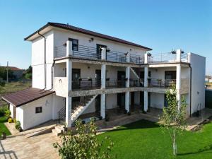a large white house with a balcony at Casa Giulia in Vama Veche