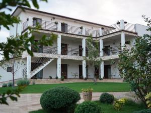 a large white building with balconies and a yard at Casa Giulia in Vama Veche