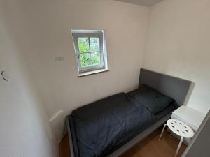 a small bed in a room with a window at Offingener Ferienhaus & Monteurhaus in Offingen