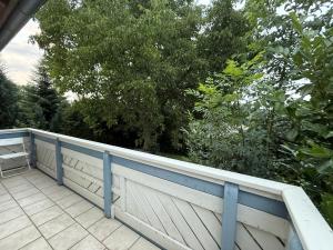 a white fence on a porch with trees at Offingener Ferienhaus & Monteurhaus in Offingen