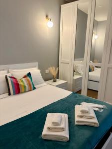 a bedroom with a large white bed with towels on it at AB apartment Pistoia in Pistoia