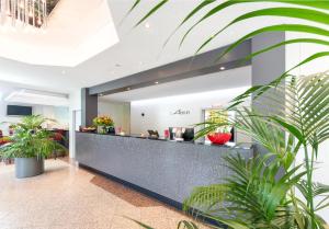 eine Bürolobby mit Pflanzen im Vordergrund in der Unterkunft Hotel Alarun Munich by Mayburgh in Unterschleißheim