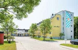 ein Gebäude, vor dem ein Auto geparkt ist in der Unterkunft Hotel Alarun Munich by Mayburgh in Unterschleißheim