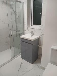 a white bathroom with a sink and a shower at Milton Keynes Lettings in Milton Keynes