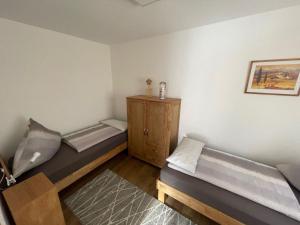 a room with two beds and a wooden cabinet at Apartment Fewo Wilhelm by Interhome in Scholis