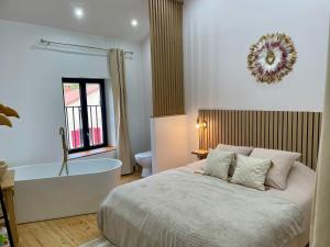 a bedroom with a bed and a bathtub and a bath tub at Maison de charme - Le Palha in Blesle