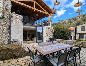 a patio with a wooden table and chairs at Maison de charme - Le Palha in Blesle
