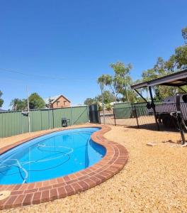 a swimming pool in a yard with a bench at Sheik Oasis in Lightning Ridge