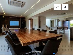 a dining room with a large wooden table and chairs at Mansão 5 Suítes - Piscina - Cozinheira - até 16 pessoas - Praia Milionários - Ilheus in Ilhéus +41 photos