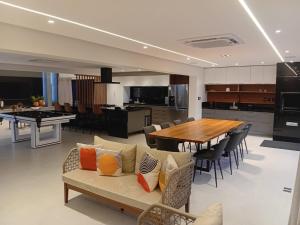 a living room and kitchen with a couch and a table at Mansão 5 Suítes - Piscina - Cozinheira - até 16 pessoas - Praia Milionários - Ilheus in Ilhéus