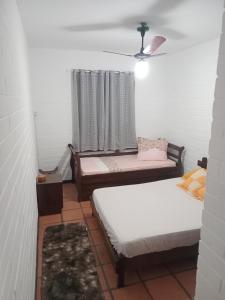 a room with two beds and a window at CASA ENSEADA - Ótima localização in Guarujá +11 photos