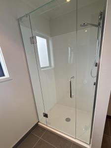 a shower with a glass door in a bathroom at Pine Holt Cottage in Warkworth +50 photos