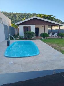 a swimming pool in front of a house at CASA ENSEADA - Ótima localização in Guarujá