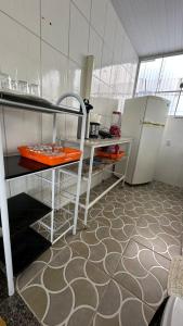 a kitchen with a refrigerator and a table in it at Hospedagem da Bela Quarto 4 Banheiro compartilhado in Caparaó Velho