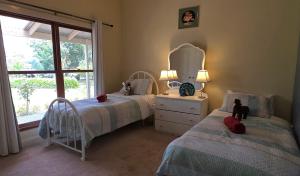 a bedroom with two beds and a mirror and a window at JillyPark Farmstay Experience Discover Authentic Farm Life Complimentary Breakfast Included in Buln Buln