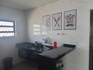 a kitchen with a counter and a sink in a room at CASA ENSEADA - Ótima localização in Guarujá