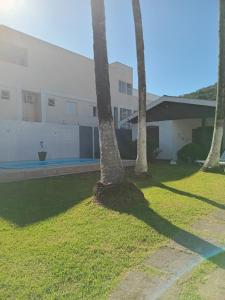 a group of palm trees in front of a building at CASA ENSEADA - Ótima localização in Guarujá