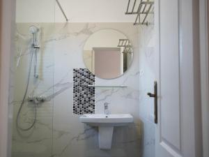 a white bathroom with a sink and a mirror at Casa Giulia in Vama Veche