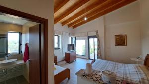 a bedroom with a bed and a bathroom with a sink at Seaview Villa Theologos in Theologos +13 photos