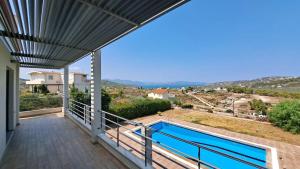 a balcony with a view of a swimming pool at Seaview Villa Theologos in Theologos