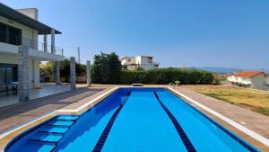 a swimming pool in front of a house at Seaview Villa Theologos in Theologos