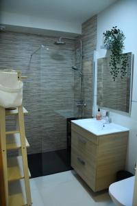 a bathroom with a shower and a sink and a mirror at Caretta Beach Destino in Morro del Jable +13 photos