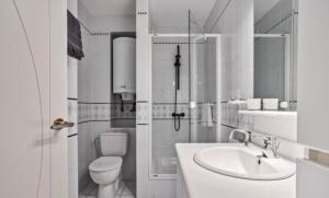 a white bathroom with a toilet and a sink at Appartemment familial à Westende in Westende-Bad +36 photos