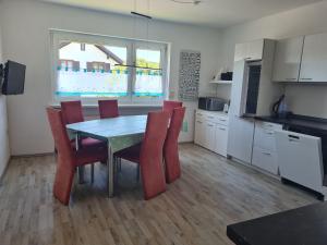 a kitchen with a table and red chairs in a room at Apartment Lusen by Interhome in Frauenau